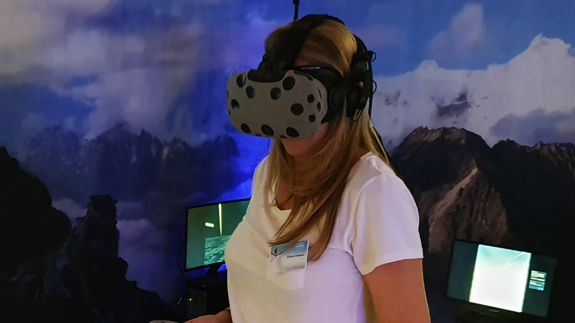 Audience watching synchronized VR video output on ambient event screens