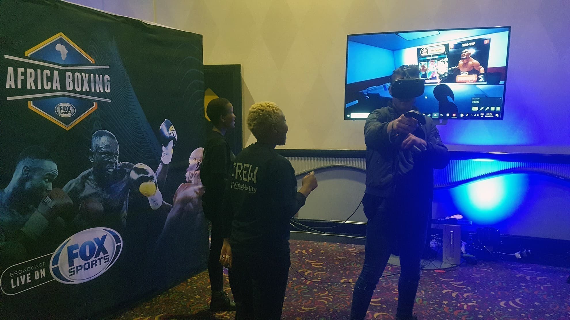 A participant boxing in virtual reality beside FOX Africa Boxing branding