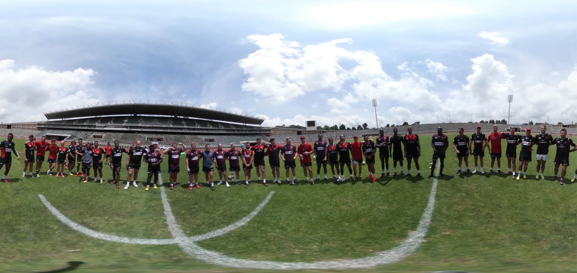 A panoramic view of rugby players lined up on the pitch