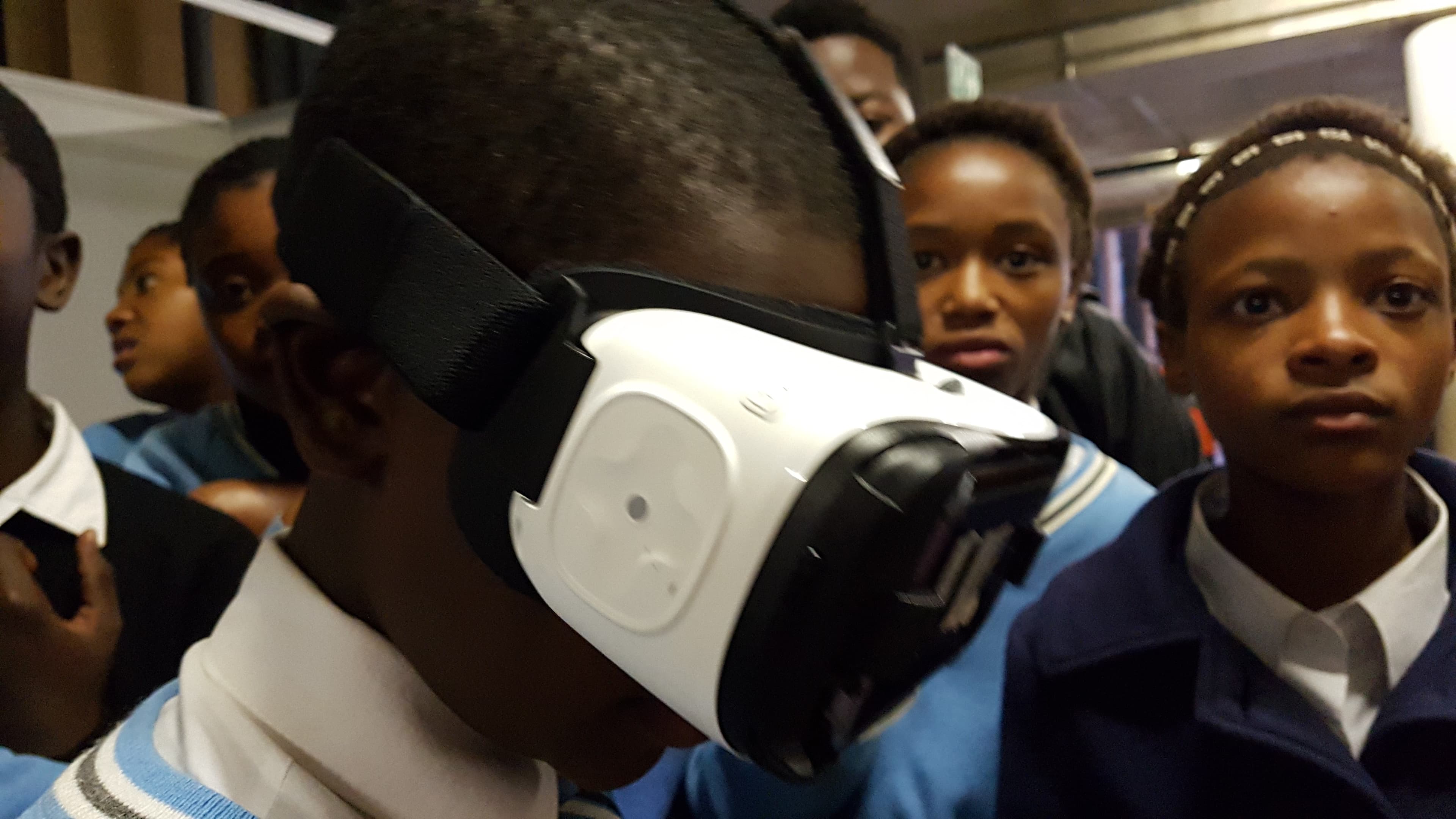 A young learner using a virtual reality headset while other learners watch in South Africa
