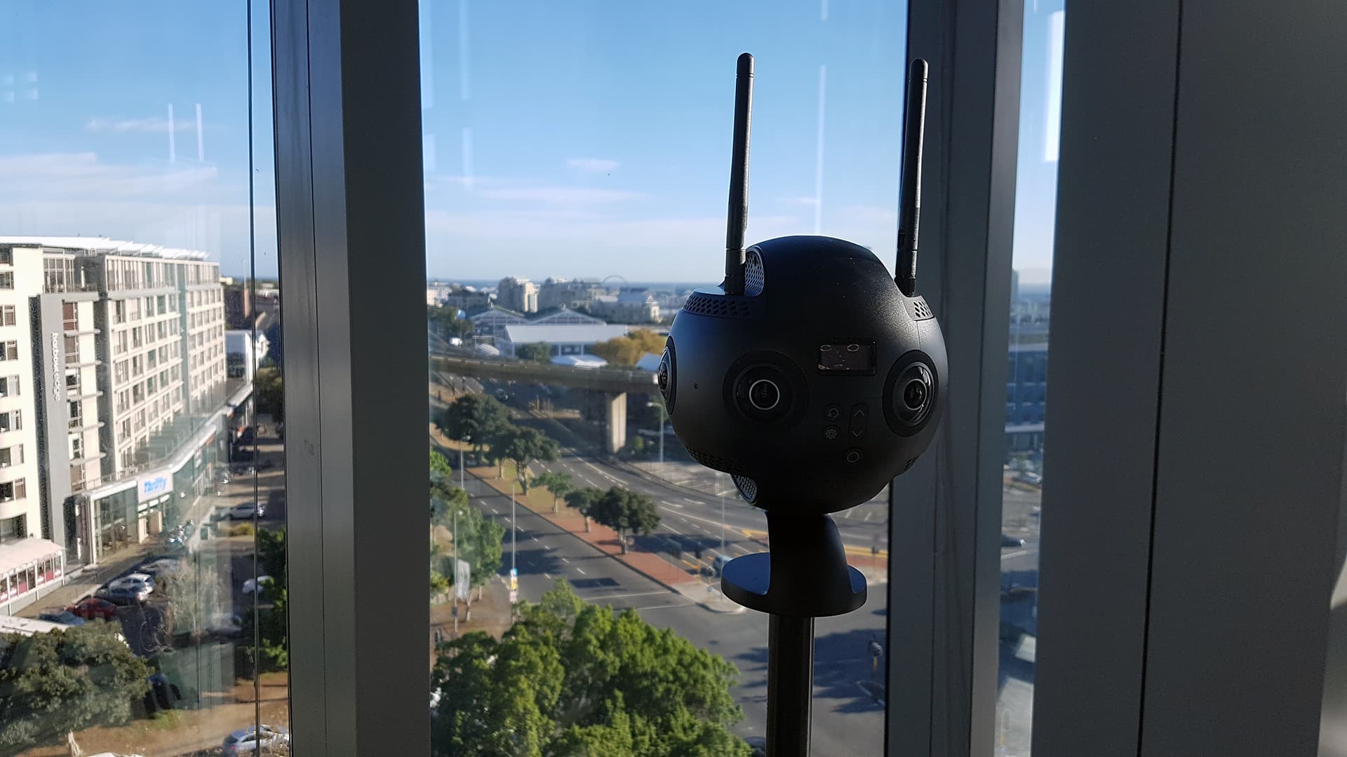 An Insta360 Pro 2 camera positioned beside a window overlooking Cape Town