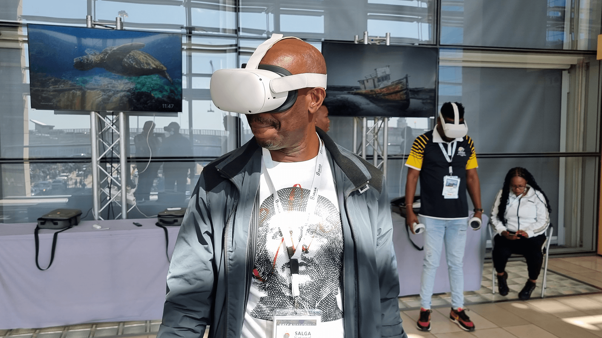 A visitor using a VR headset at an exhibition with a facilitator nearby