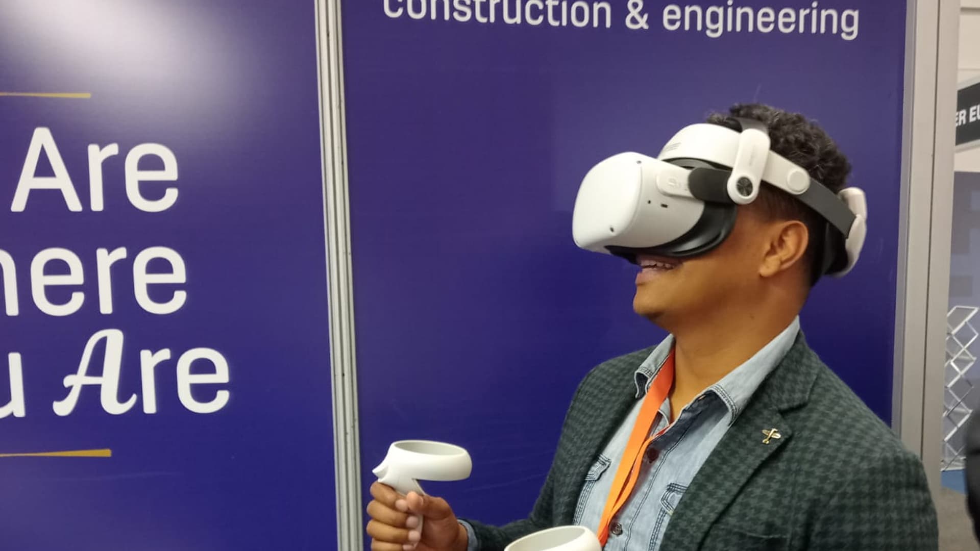 A participant using a VR headset and controller at a Hollard event stand