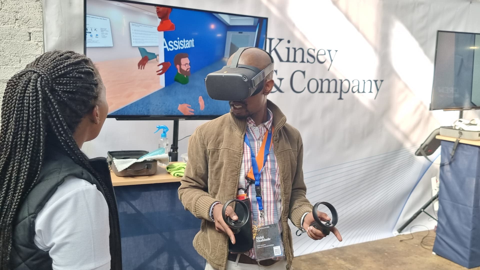 A guest using a VR headset and controllers at the McKinsey & Company activation