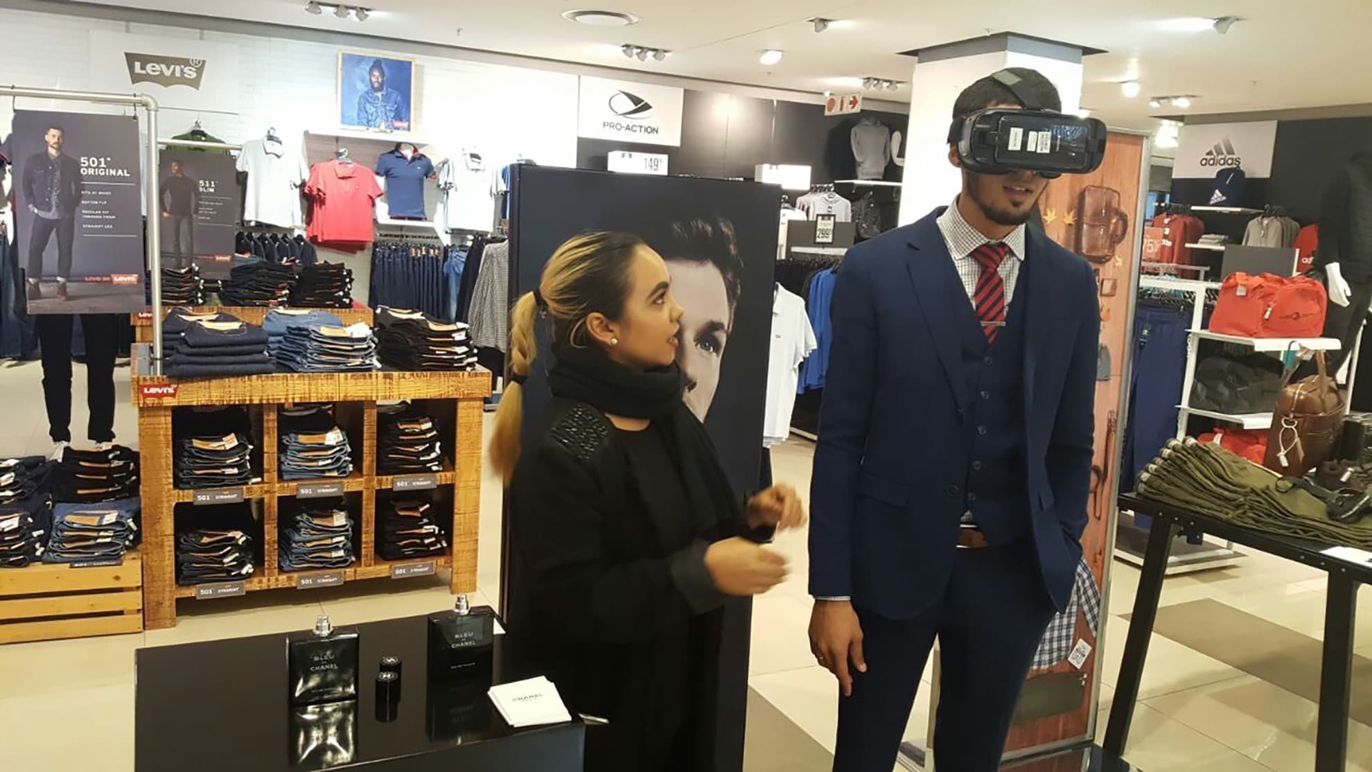 Participant using Gear VR beside event equipment and a screen