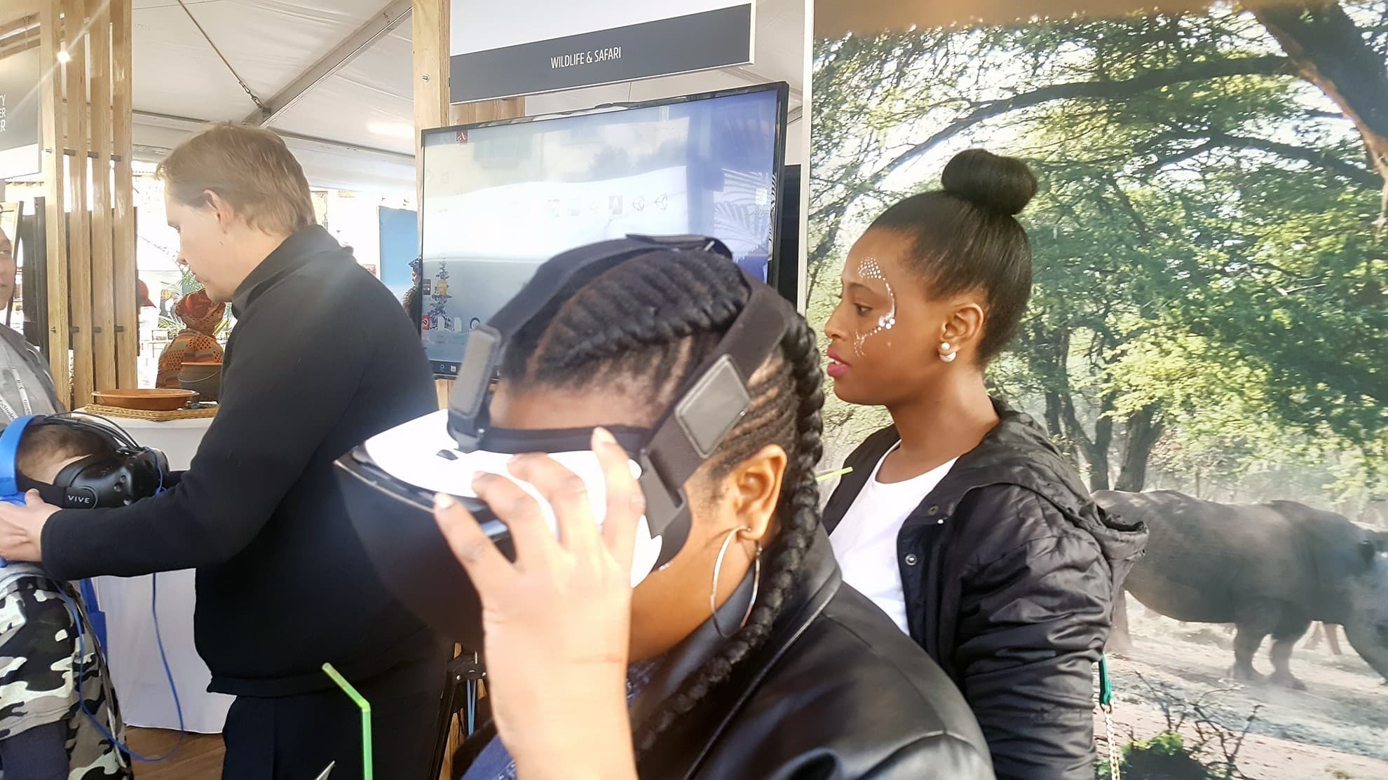 Participant adjusting a headset with a facilitator nearby