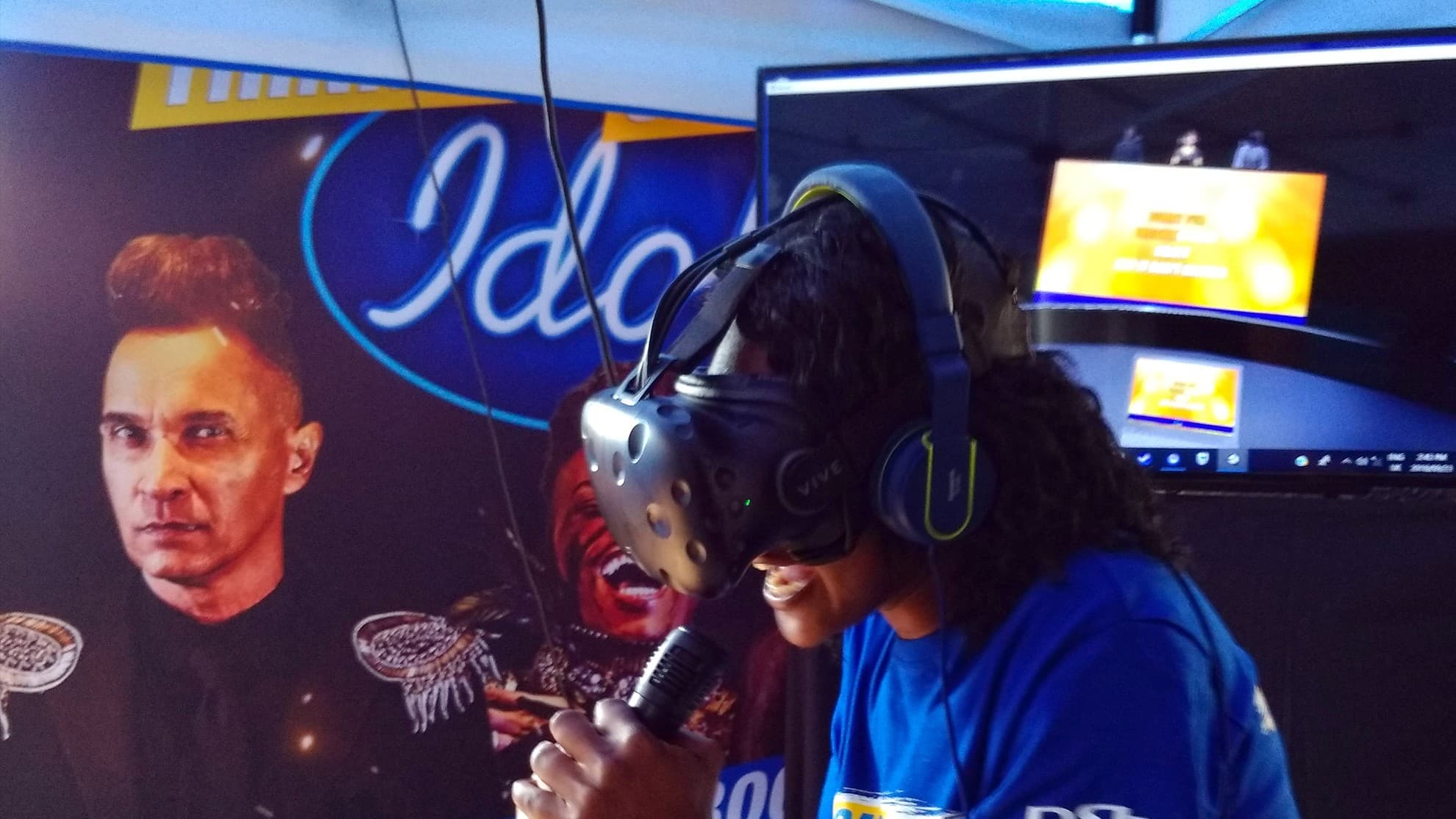 Contestant wearing a VR headset singing in the DStv Compact Karaoke VR Game